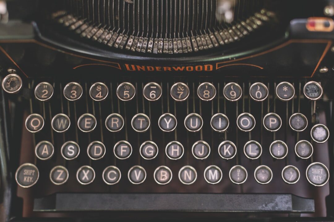 Vintage typewriter on a wooden desk with notes and a magnifying glass