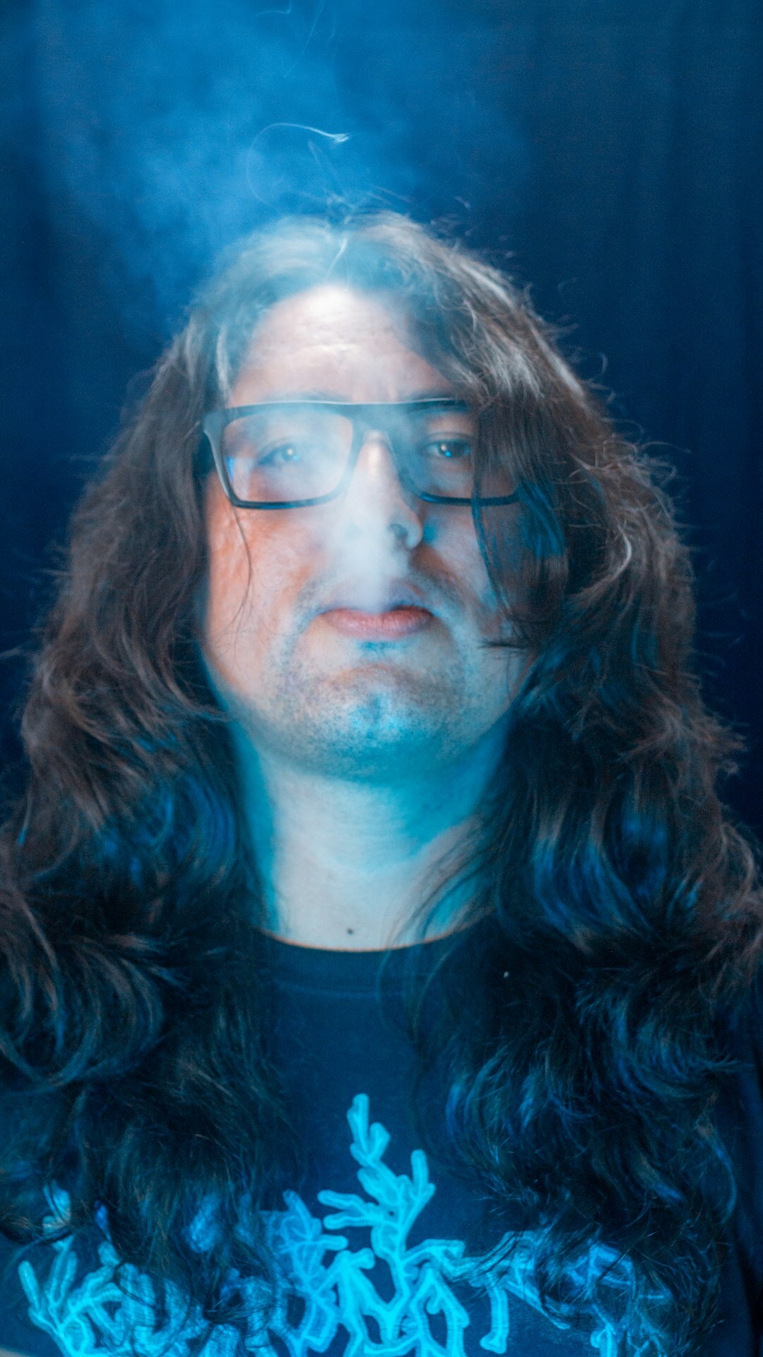 Studio portrait of a middle-aged man with glasses and a beard
